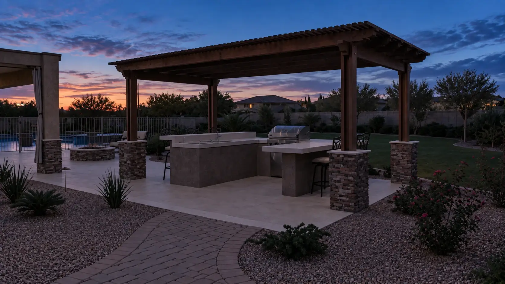 Example of a backyard pergola and outdoor kitchen at dusk with no lighting