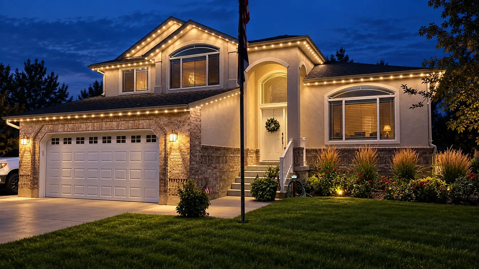 Two-story stucco and brick home with warm-white permanent LED roofline lighting at dusk