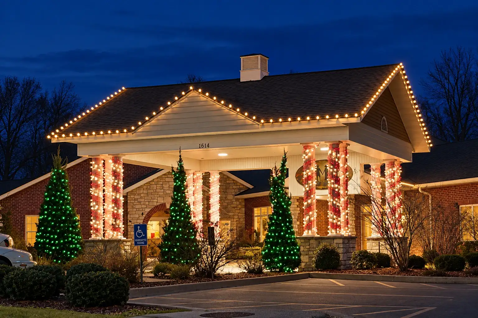 Commercial pavilion with warm-white roofline lights and lit trees and columns at night