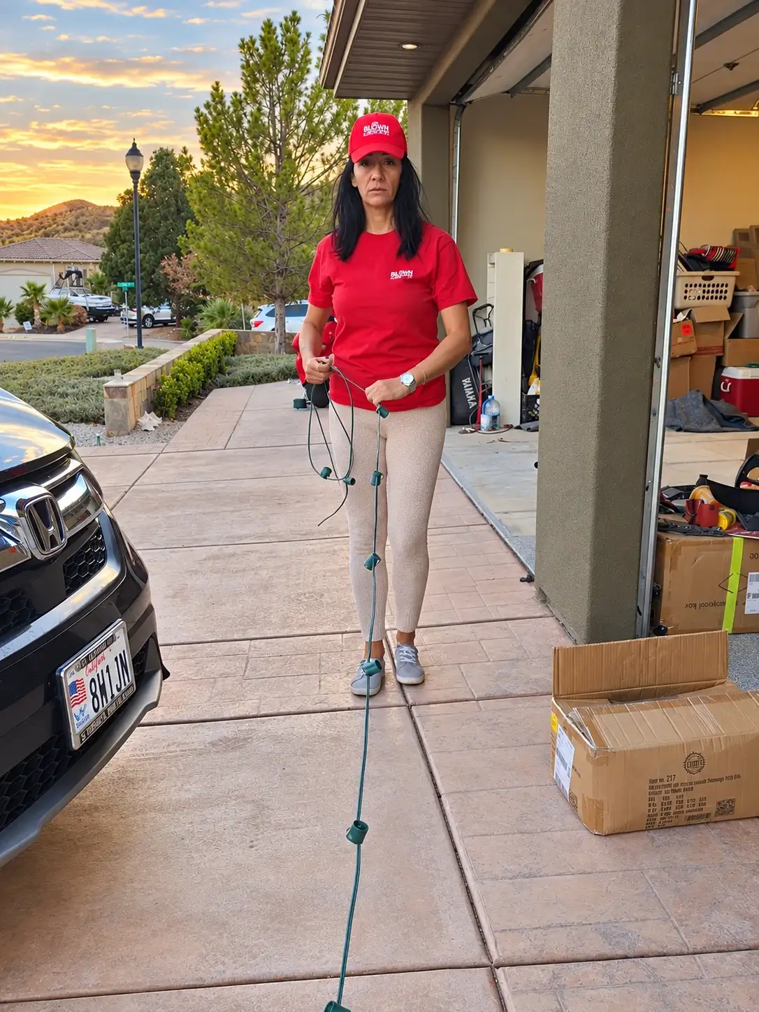 Glow Forward team member laying out a light strand on a driveway