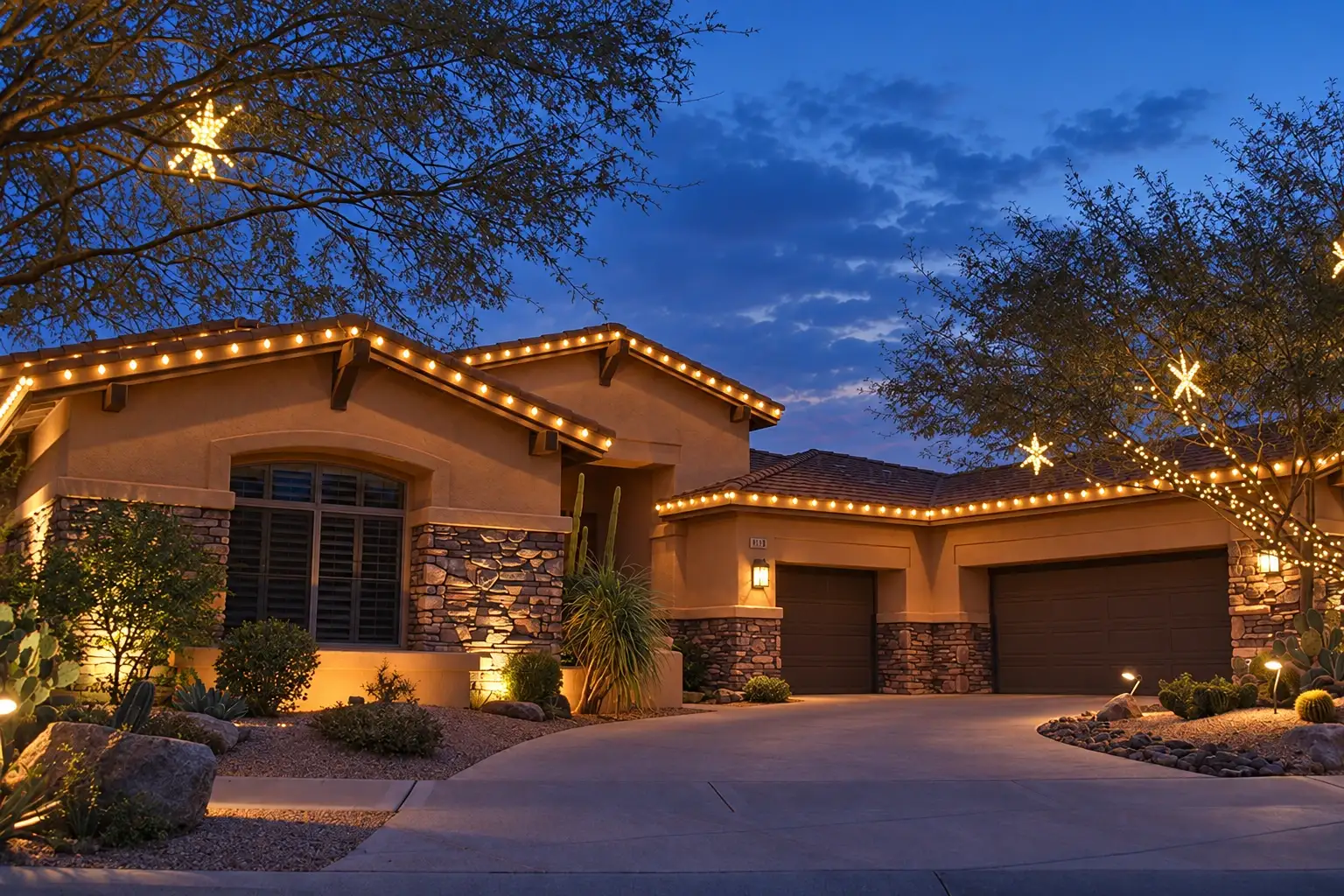 Desert home with warm-white roofline lights and lit trees at blue hour